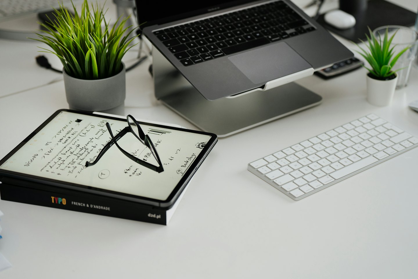 Ordinateur portable et tablette sur un bureau moderne, propre et organisé.